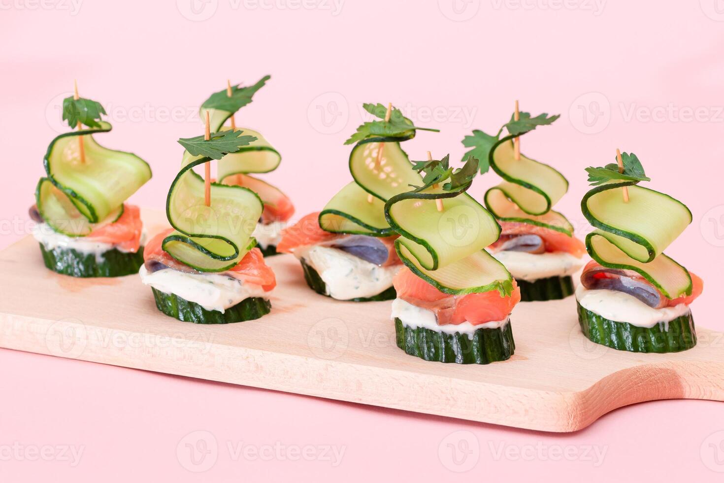 Canapes without Bread with Fresh Salmon, Cucumber and Cream Cheese on Wooden Cutting Board. Easy Breakfast. Diet Food. Quick and Healthy Sandwiches. Healthy Snacks with Tasty Fillings photo