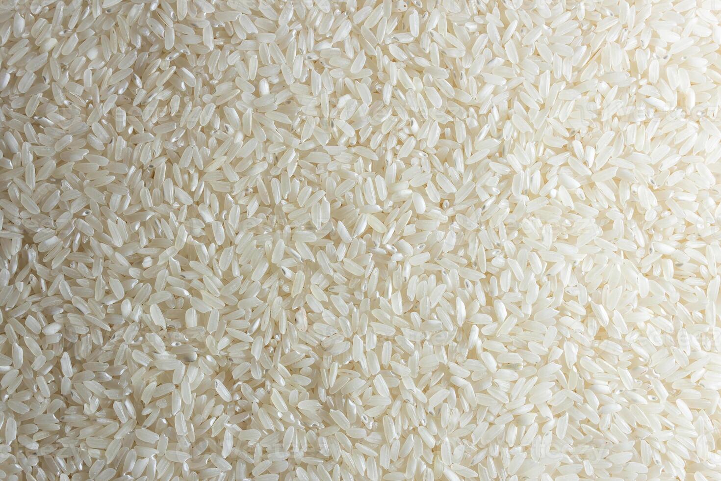 Dry Uncooked White Rice Background - Top View, Flat Lay. Scattered Raw Long Grain Rice. Asian Cuisine and Culture. Healthy Eating Ingredients. Diet Food photo