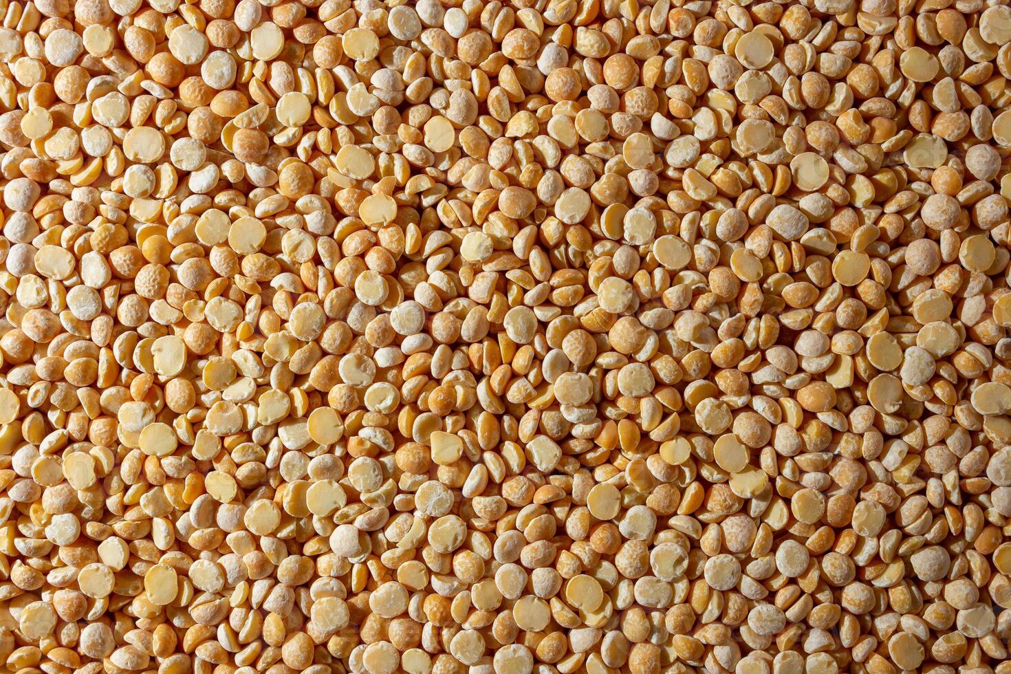 Uncooked Polished Split Peas Background. A Culinary Canvas of Dry Yellow Peas, Creating a Lively and Textured Background for Gourmet Cooking. Scattered Raw Polished Peas. Healthy Eating Ingredients photo