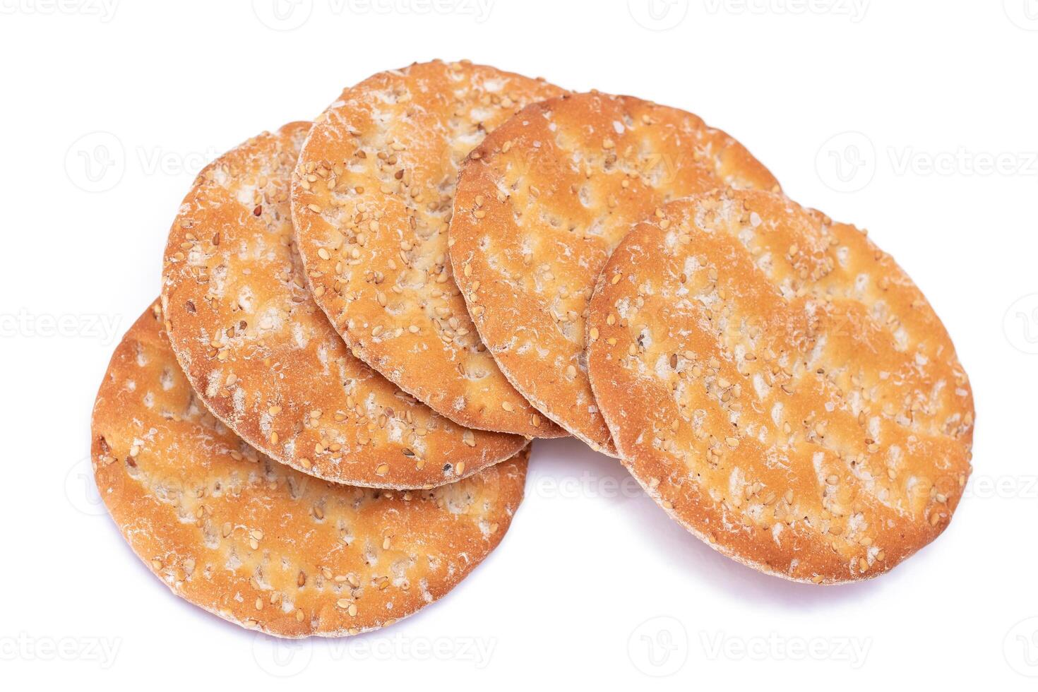 A Heap of Round Salt Crackers with Sesame Isolated on White Background. Dry Snacks - Isolation photo