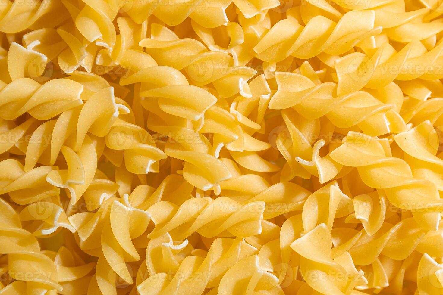 Uncooked Fusilli Pasta. A Culinary Canvas of Spiral Macaroni, Creating a Lively and Textured Background for Gourmet Cooking. Dry Pasta. Raw Macaroni - Top View, Flat Lay photo
