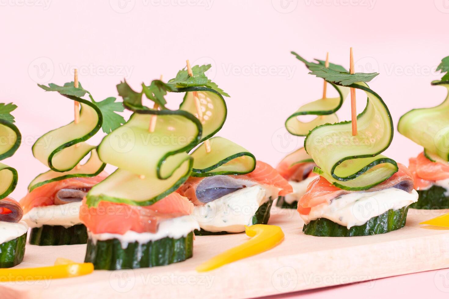 Canapes without Bread with Fresh Salmon, Cucumber and Cream Cheese on Wooden Cutting Board. Easy Breakfast. Diet Food. Quick and Healthy Sandwiches. Healthy Snacks with Tasty Fillings photo