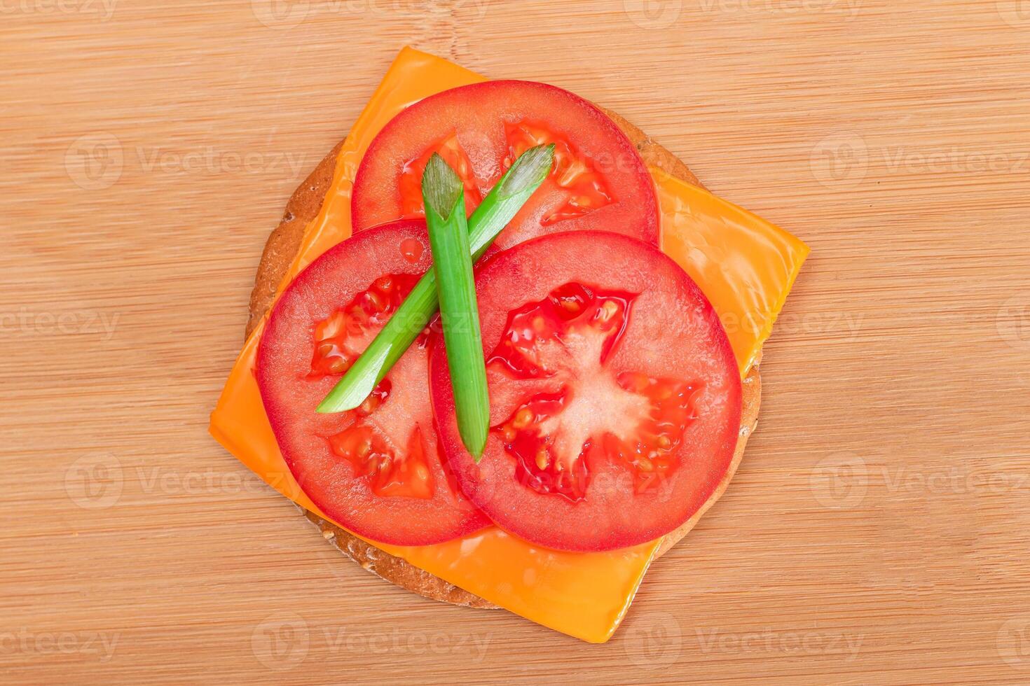 Crispy Cracker Sandwich with Tomato, Cheese and Green Onions on Cutting Board. Easy Breakfast. Diet Food. Quick and Healthy Sandwiches. Crispbread with Tasty Filling. Healthy Dietary Snack photo