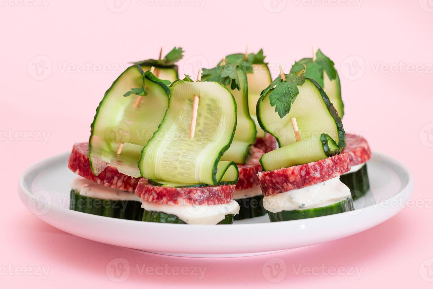 Canapes without Bread with Salami, Cucumber, Greens and Cream Cheese on White Plate. Easy Breakfast. Diet Food. Quick and Healthy Sandwiches. Healthy Snacks with Tasty Fillings photo