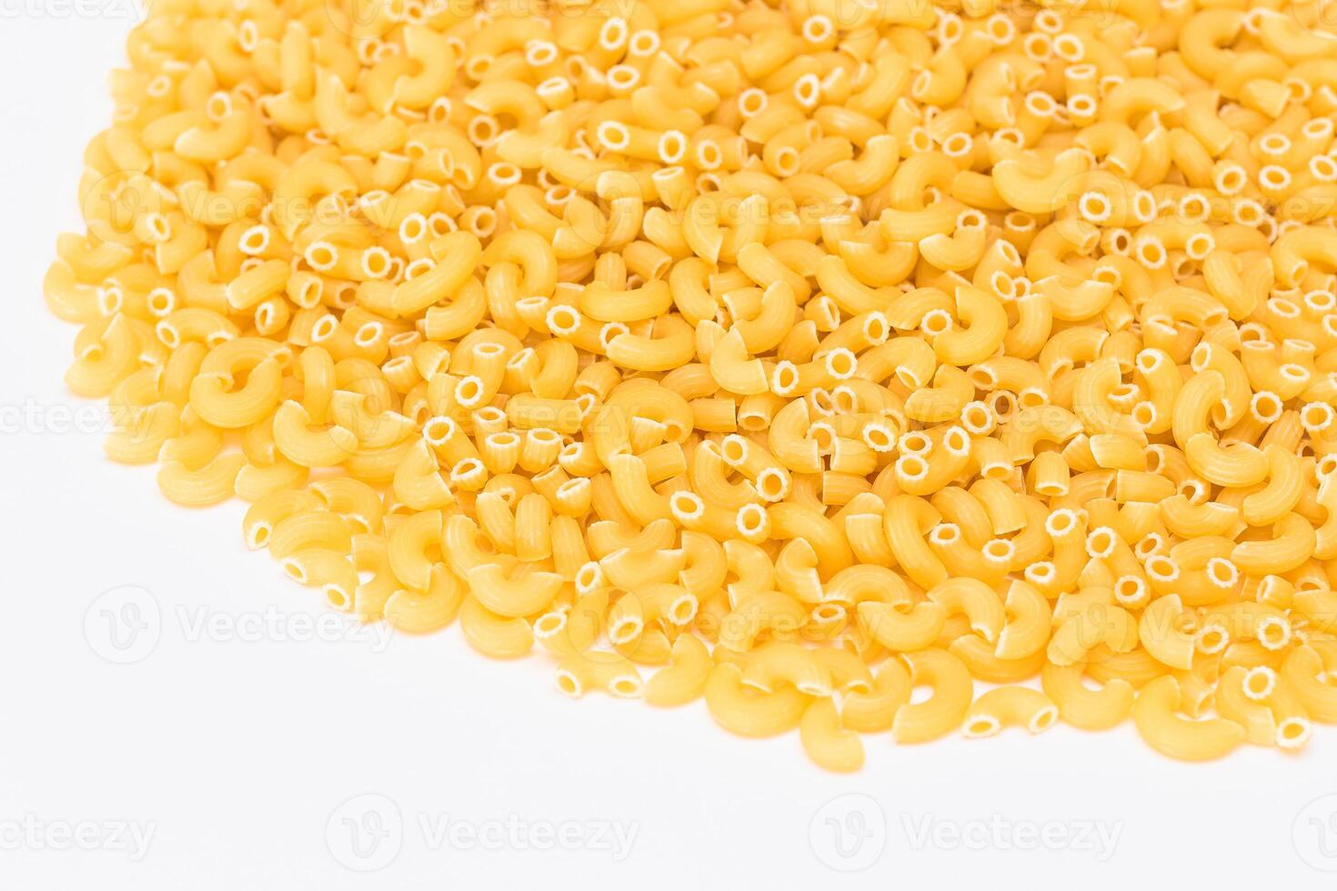 A Heap of Uncooked Chifferi Rigati Pasta on White Background. Fat and Unhealthy Food. Classic Dry Macaroni Texture. Italian Culture and Cuisine. Raw Pasta photo