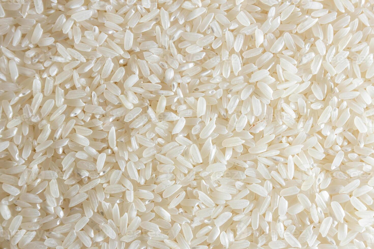 Dry Uncooked White Rice Background - Top View, Flat Lay. Scattered Raw Long Grain Rice. Asian Cuisine and Culture. Healthy Eating Ingredients. Diet Food photo