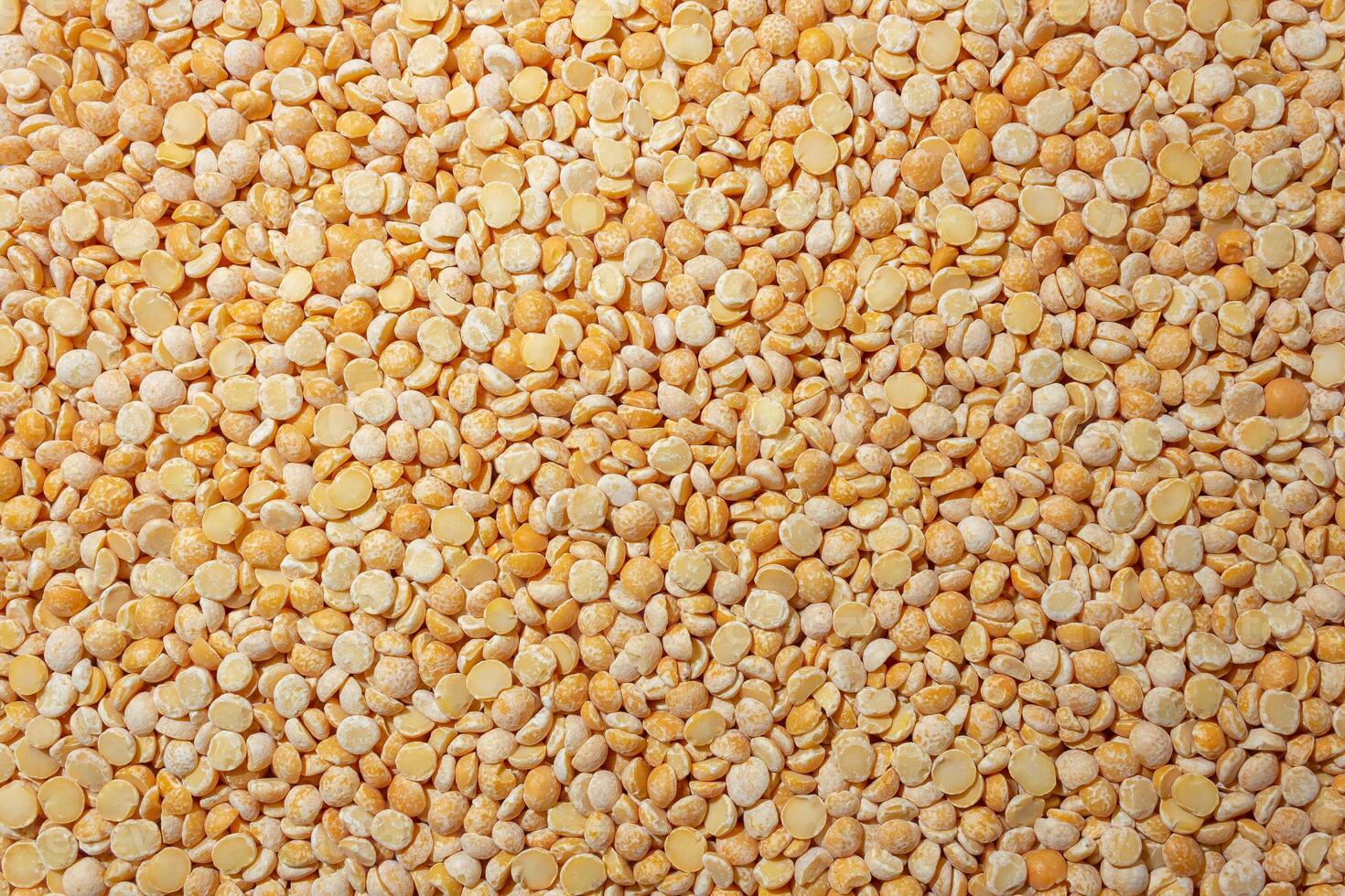 Uncooked Polished Split Peas Background. A Culinary Canvas of Dry Yellow Peas, Creating a Lively and Textured Background for Gourmet Cooking. Scattered Raw Polished Peas. Healthy Eating Ingredients photo