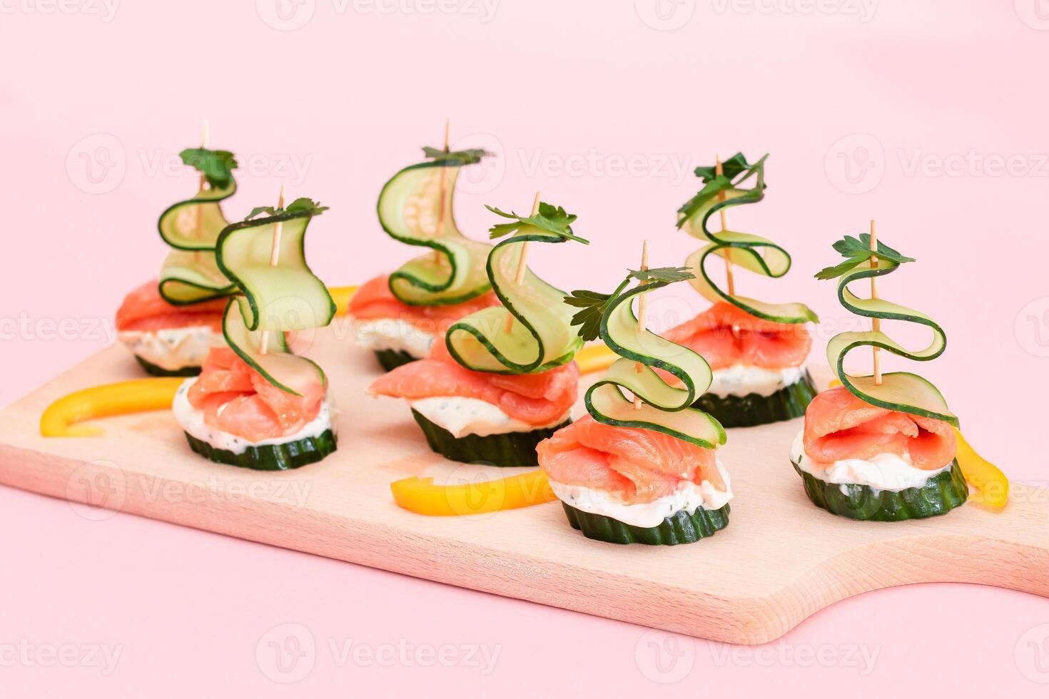 Canapes without Bread with Fresh Salmon, Cucumber and Cream Cheese on Wooden Cutting Board. Easy Breakfast. Diet Food. Quick and Healthy Sandwiches. Healthy Snacks with Tasty Fillings photo