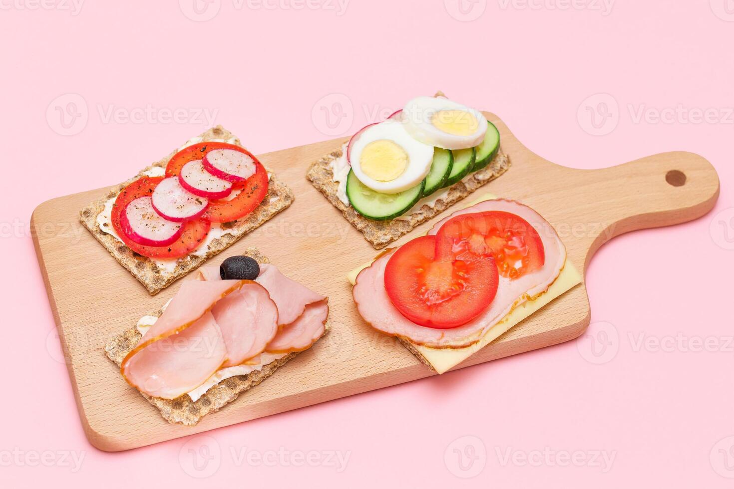 Different Whole Grain Crispbread with Ham, Tomato, Radish, Cucumber and Cheese. Easy Breakfast. Diet Food. Quick and Healthy Sandwiches. Crispbread with Tasty Filling. Healthy Dietary Snack photo