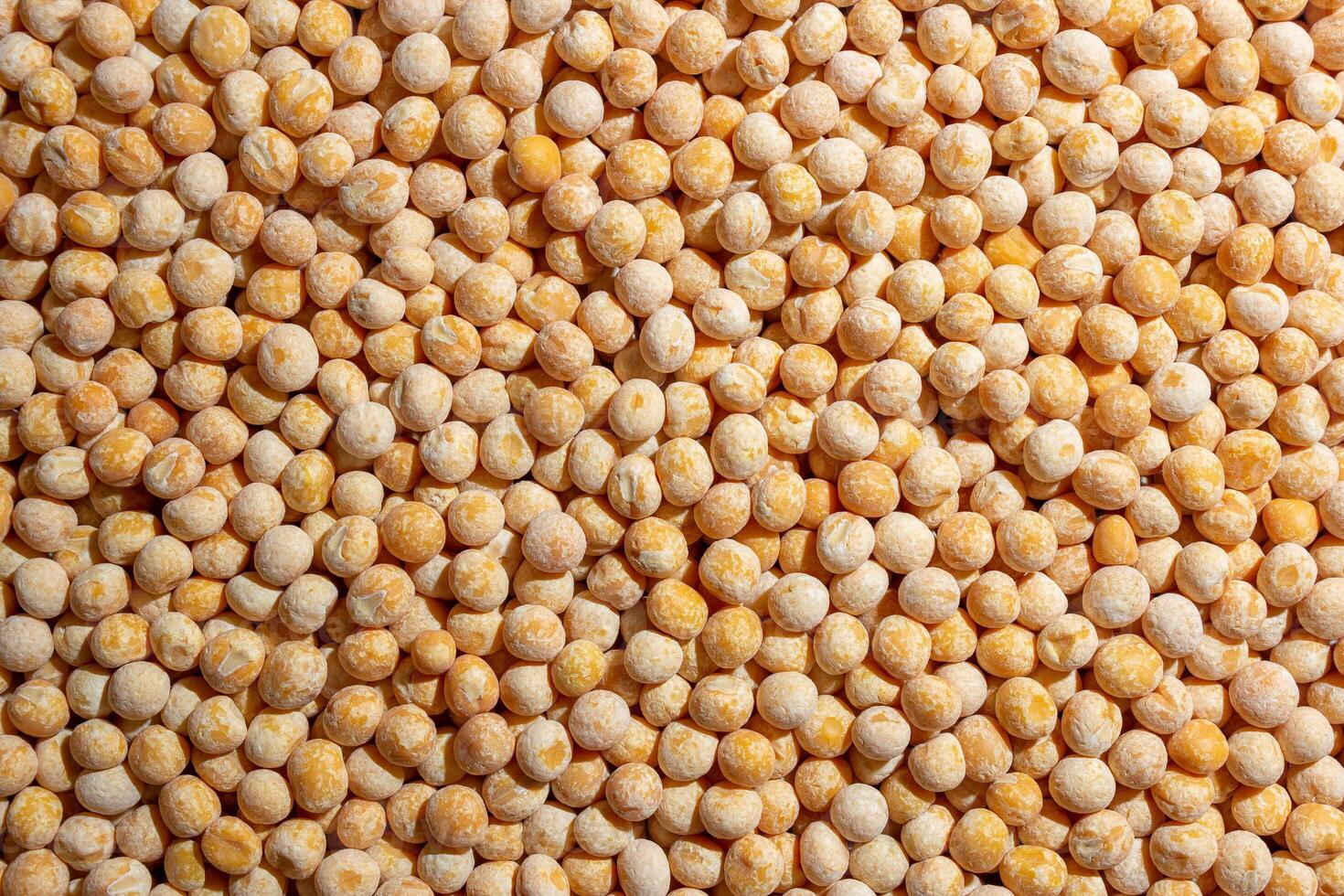 Uncooked Yellow Polished Peas Background. A Culinary Canvas of Dry Yellow Peas, Creating a Lively and Textured Background for Gourmet Cooking. Scattered Raw Polished Peas. Healthy Eating Ingredients photo