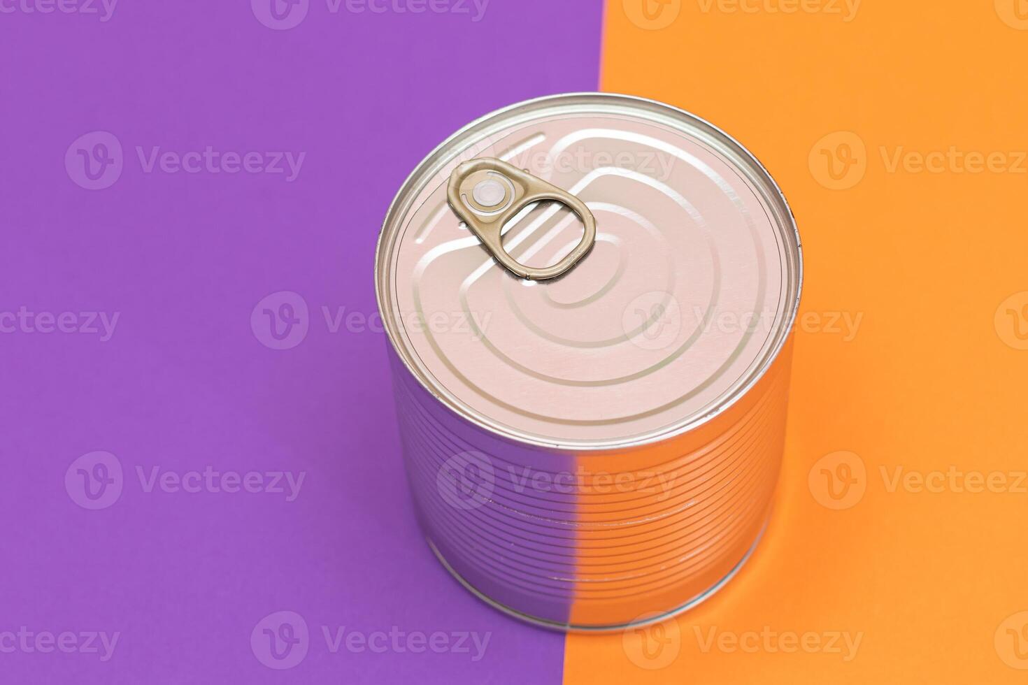 Unopened Tin Can on Split Orange and Violet Background. Canned Food. Aluminum Can for Safe and Long Term Storage of Food. Steel Sealed Food Storage Container photo