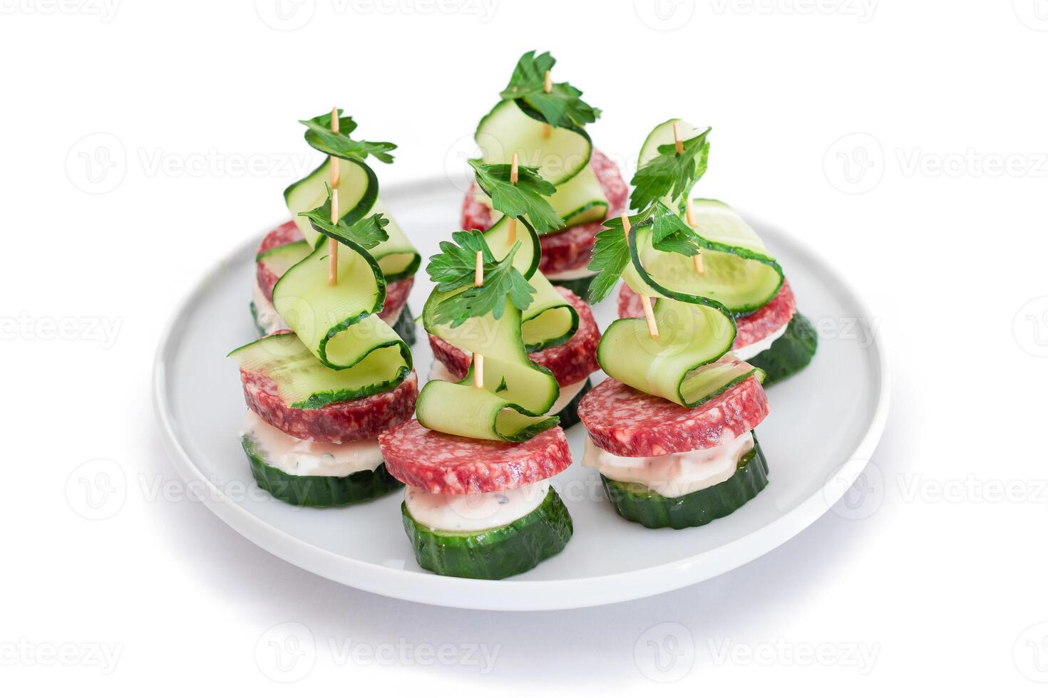 Canapes without Bread with Salami, Cucumber, Greens and Cream Cheese on White Plate - Isolated on White. Easy Breakfast. Diet Food. Quick and Healthy Sandwiches. Healthy Snacks with Tasty Fillings photo