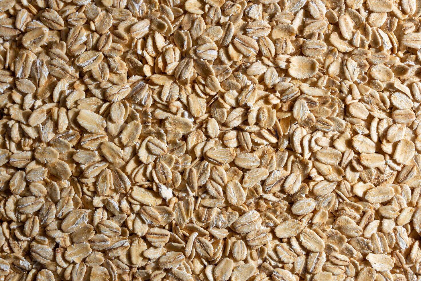 Uncooked Oat Flakes background - Top View, Flat Lay. Scattered Dry and Raw Oat Flakes. Healthy Breakfast and Diet Eating Ingredients photo