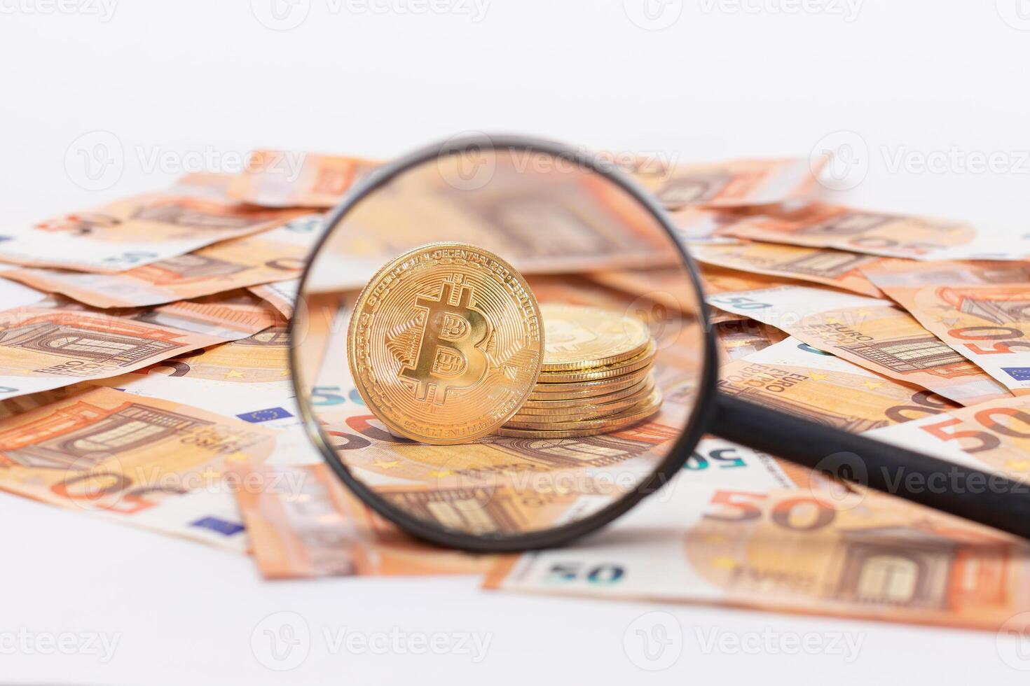 A Stack of Bitcoin Coins Visible Through a Magnifying Glass on the 50-Euro Banknotes. Euro Currency and Crypto Currency. Orange Paper Money. A Lot of Fifty-Euro Bills. Anonymous Payments Concept photo