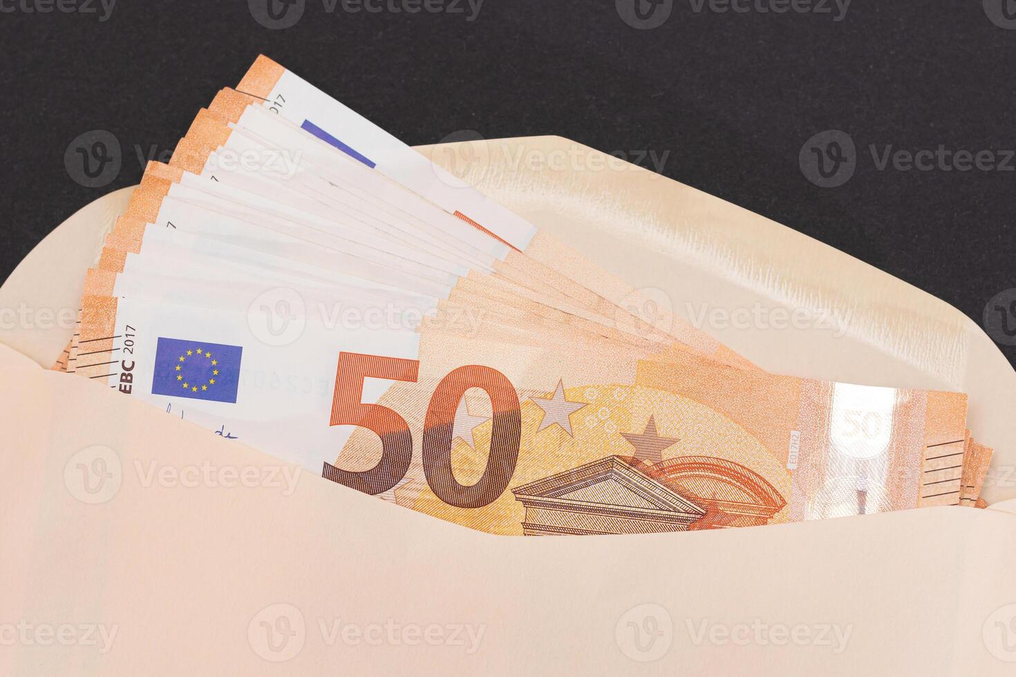 An Orange Paper Envelope with Stack of 50-Euro Banknotes Inside. Salary in Cash. Tax-Free System. Euro Currency. Payments with No Taxes. Orange Paper Money. A Lot of Fifty-Euro Bills photo
