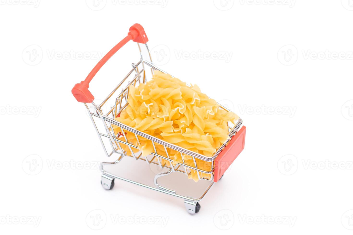 Uncooked Fusilli Pasta in Small Shopping Cart Isolated on White Background. A Crisis. Buying Cheap Food. Classic Dry Spiral Macaroni. Italian Culture and Cuisine. Raw Pasta - Isolation photo