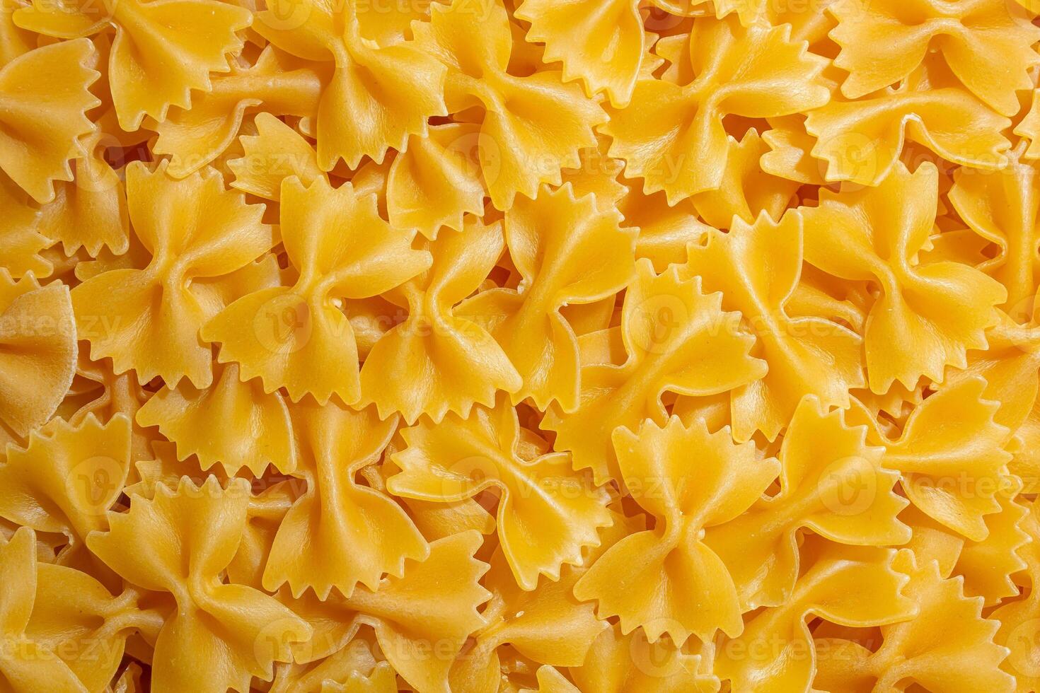 Uncooked Farfalle Pasta. A Culinary Canvas of Bow-Tie Macaroni, Creating a Lively and Textured Background for Gourmet Cooking. Dry Pasta. Raw Macaroni - Top View, Flat Lay photo
