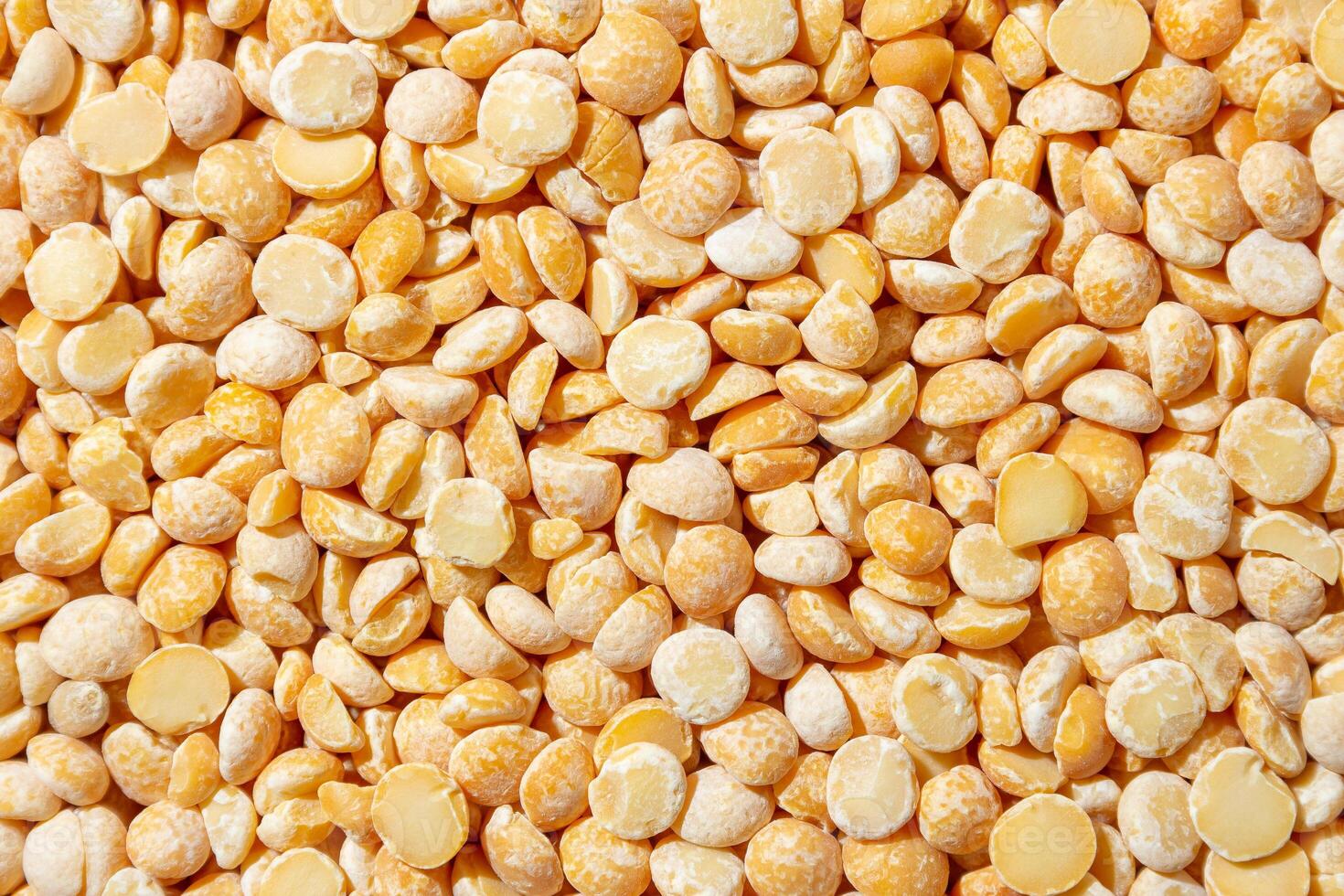 Uncooked Polished Split Peas Background. A Culinary Canvas of Dry Yellow Peas, Creating a Lively and Textured Background for Gourmet Cooking. Scattered Raw Polished Peas. Healthy Eating Ingredients photo