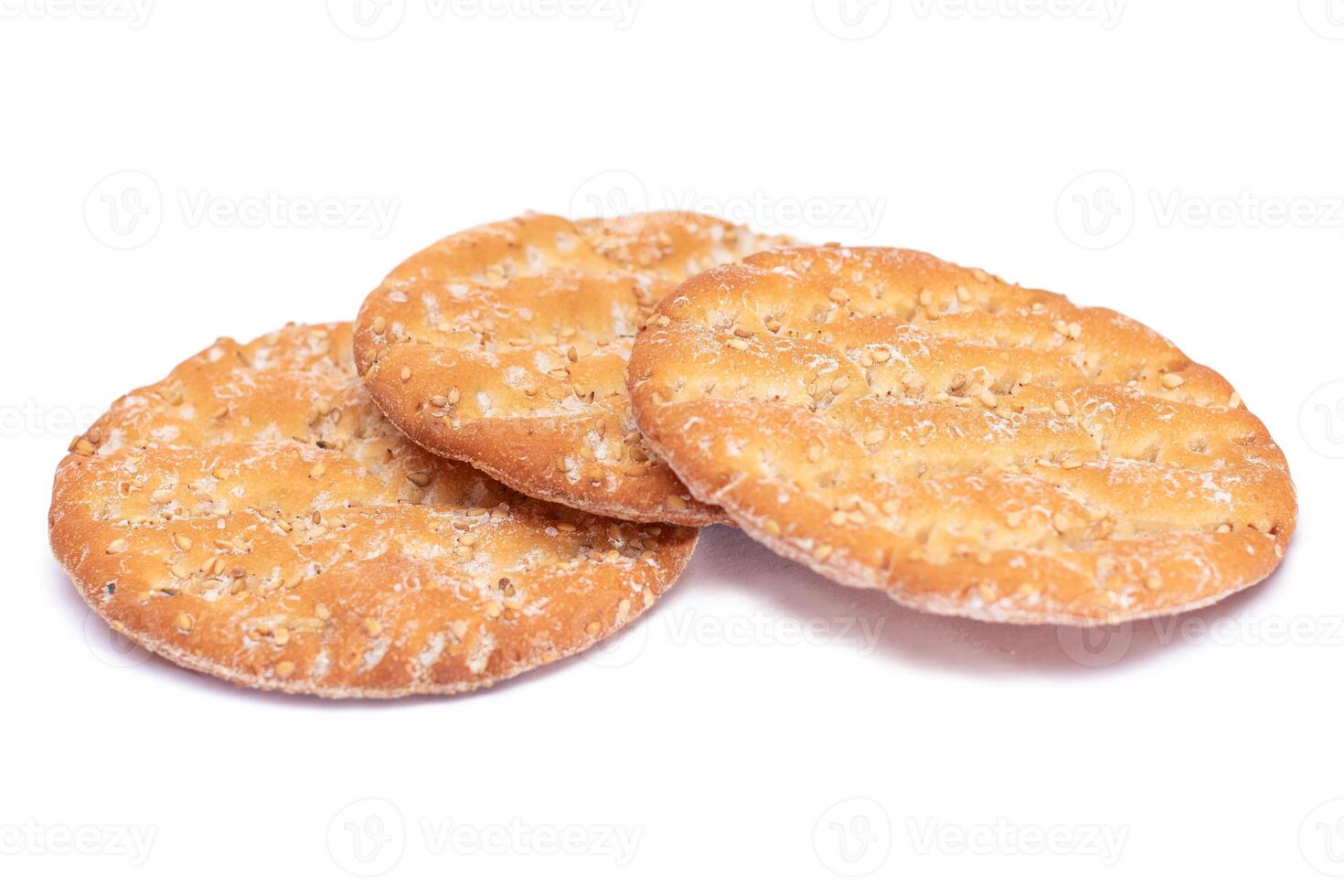 A Heap of Round Salt Crackers with Sesame Isolated on White Background. Dry Snacks - Isolation photo