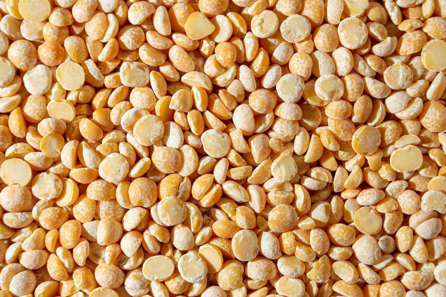 Uncooked Polished Split Peas Background. A Culinary Canvas of Dry Yellow Peas, Creating a Lively and Textured Background for Gourmet Cooking. Scattered Raw Polished Peas. Healthy Eating Ingredients photo