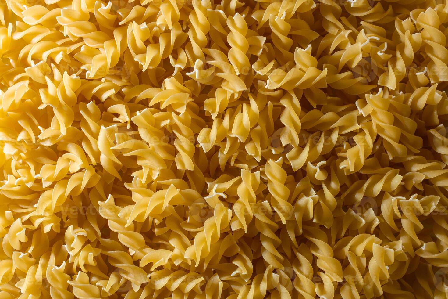 Uncooked Fusilli Pasta. A Culinary Canvas of Spiral Macaroni, Creating a Lively and Textured Background for Gourmet Cooking. Dry Pasta. Raw Macaroni - Top View, Flat Lay photo