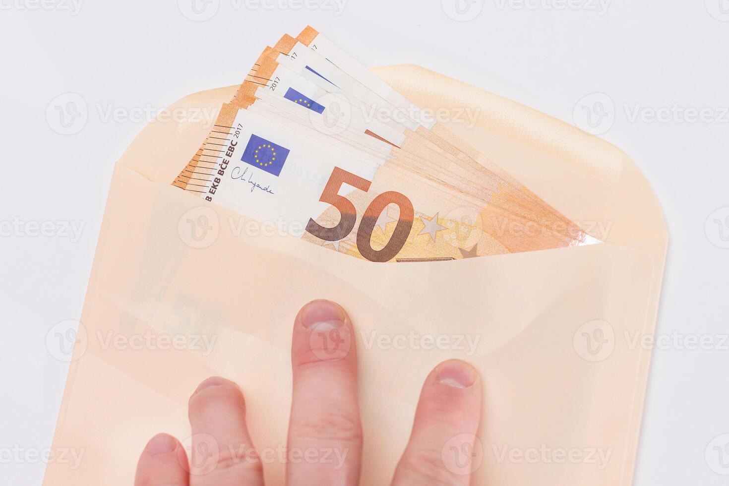 Hand Holds An Orange Paper Envelope with Stack of 50-Euro Banknotes Inside. Salary in Cash. Tax-Free System. Euro Currency. Payments with No Taxes. Orange Paper Money. A Lot of Fifty-Euro Bills photo