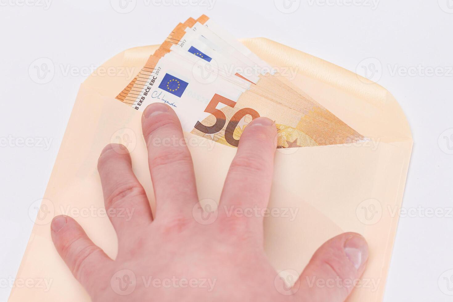 Hand Holds An Orange Paper Envelope with Stack of 50-Euro Banknotes Inside. Salary in Cash. Tax-Free System. Euro Currency. Payments with No Taxes. Orange Paper Money. A Lot of Fifty-Euro Bills photo
