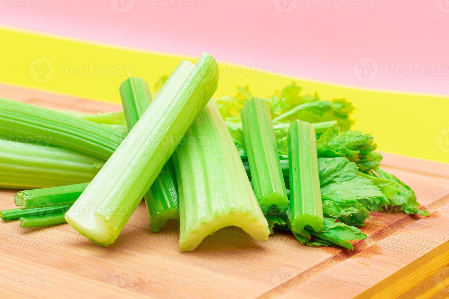 Fresh Celery Stem and Chopped Celery Sticks on Wooden Cutting Board. Vegan and Vegetarian Culture. Raw Food. Healthy Diet with Negative Calorie Content. Slimming Food photo