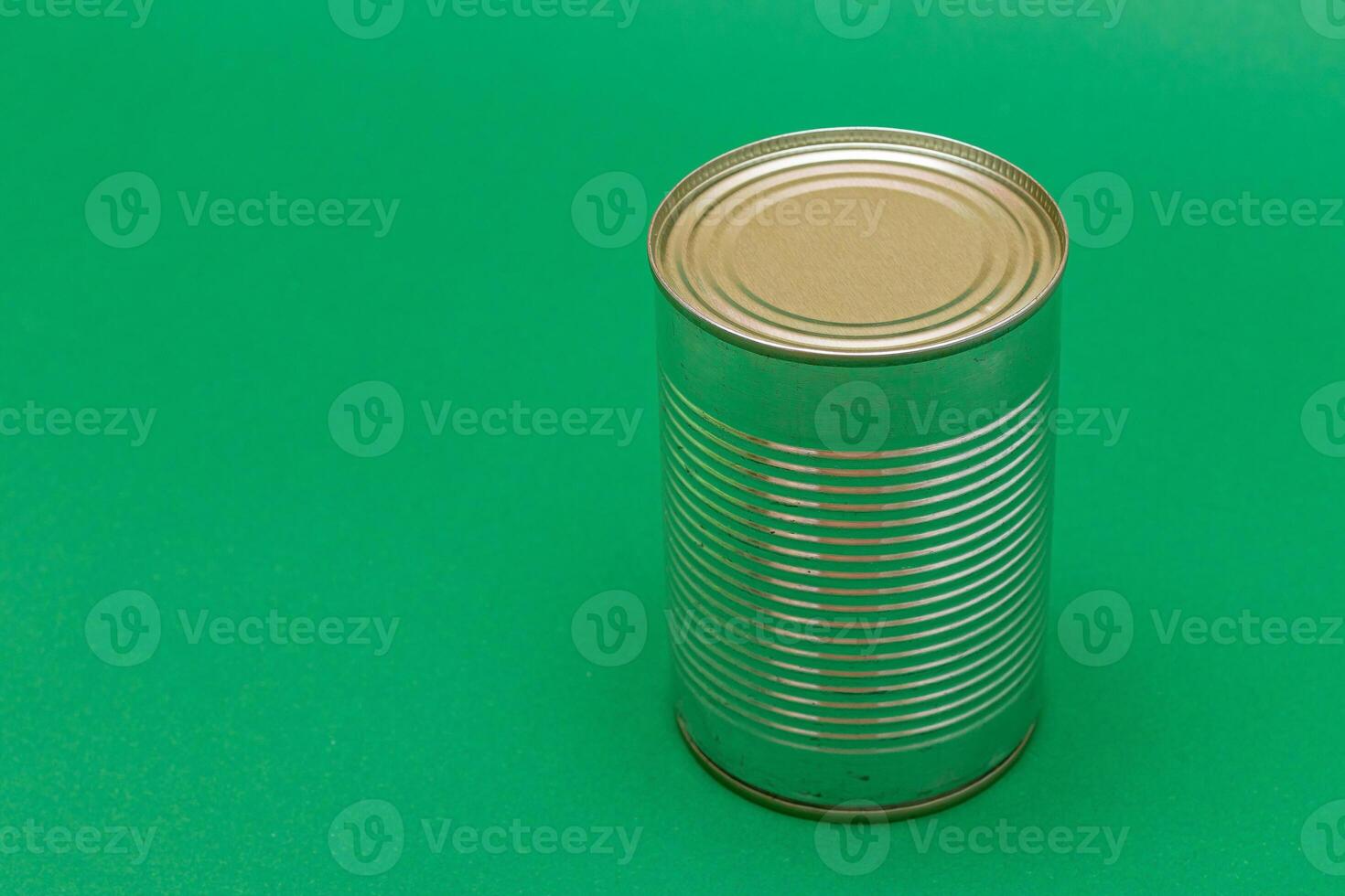 Unopened Tin Can with Blank Edge on Green Background. Canned Food. Aluminum Can for Safe and Long Term Storage of Food. Steel Sealed Food Storage Container photo