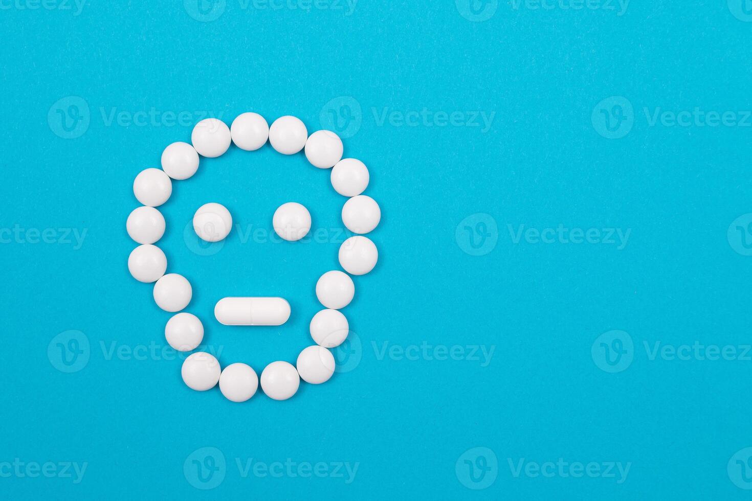 Dangerous Pharmaceutical Products or Unsafe Pills and Tablets - Skull or Death Symbol Made from White Pills Lying on Blue Background photo