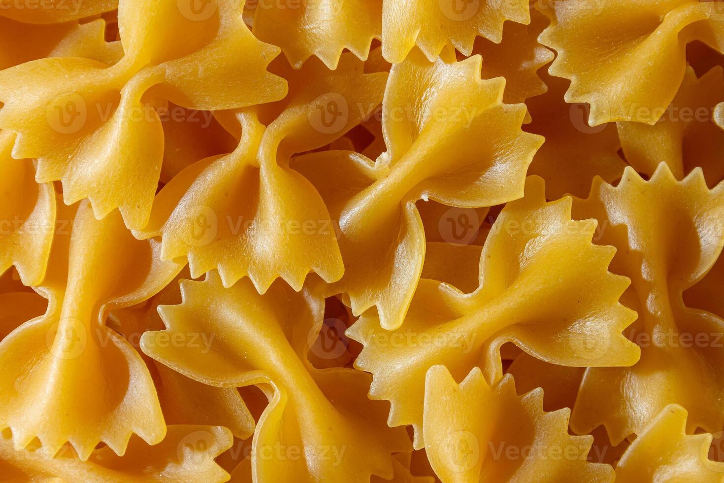 Uncooked Farfalle Pasta. A Culinary Canvas of Bow-Tie Macaroni, Creating a Lively and Textured Background for Gourmet Cooking. Dry Pasta. Raw Macaroni - Top View, Flat Lay photo