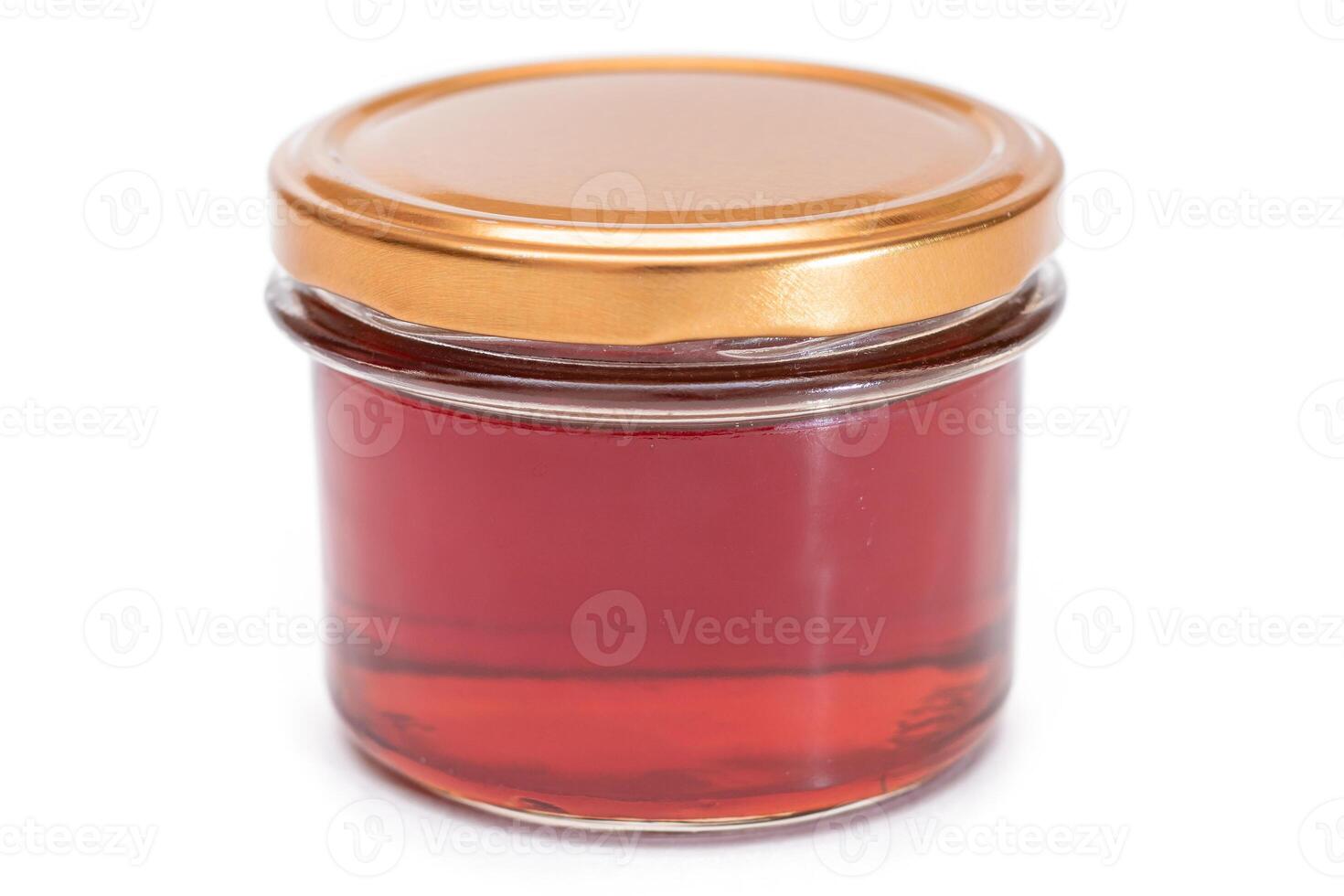 Dark Honey in a Small Glass Jar Isolated on White Background photo