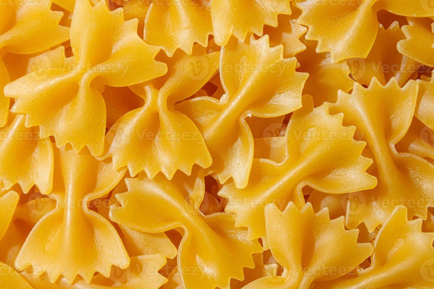 Uncooked Farfalle Pasta. A Culinary Canvas of Bow-Tie Macaroni, Creating a Lively and Textured Background for Gourmet Cooking. Dry Pasta. Raw Macaroni - Top View, Flat Lay photo