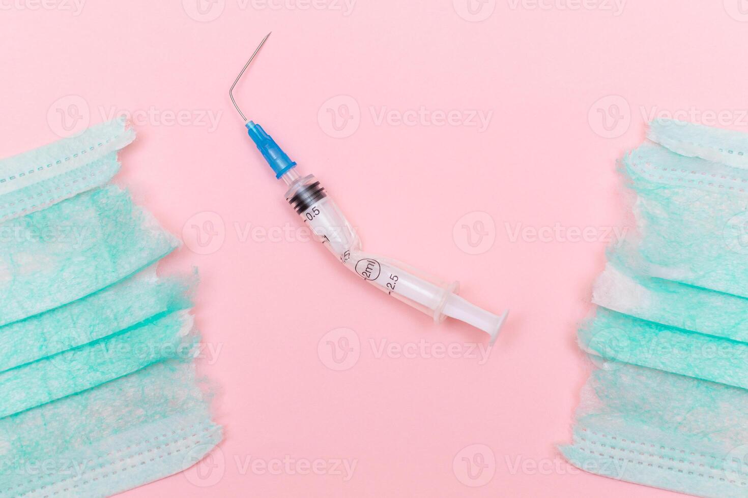 Anti Vaccine Movement and Anti Mask Concept - Broken Medical Syringe and Green Torn Medical Face Mask on the Pink Background. Pandemic and Lockdown End - Top View, Flat Lay photo