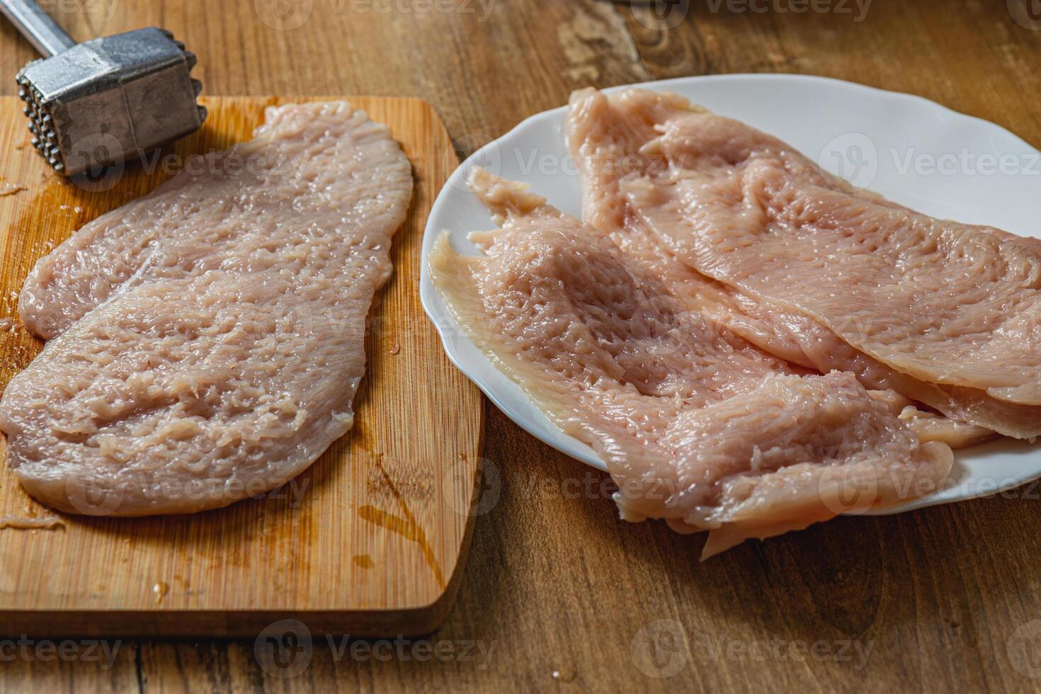 hammering fillet for chop on kitchen table photo