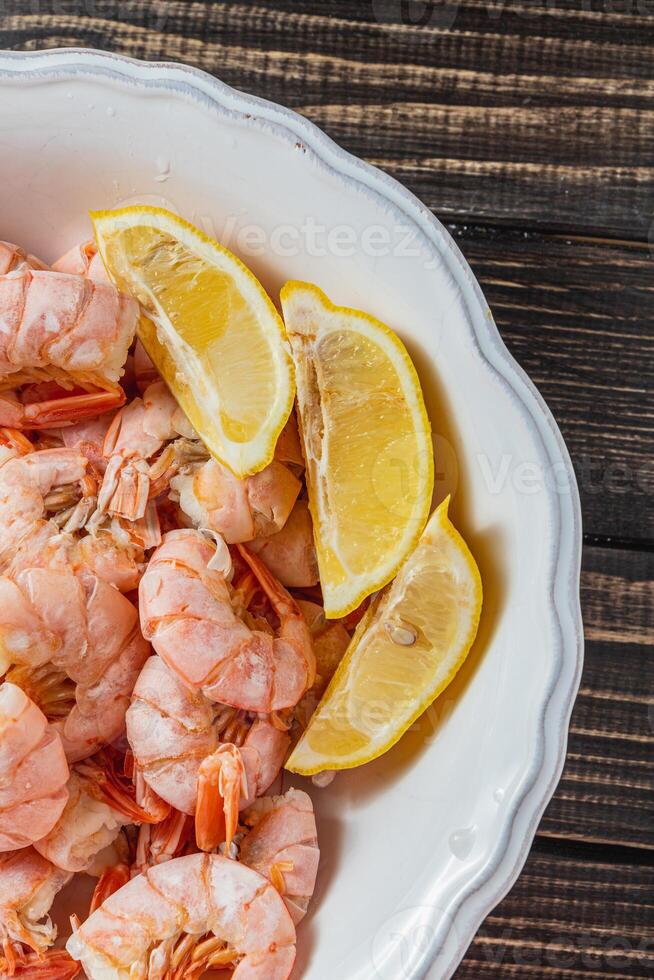 Boiled king prawns in a deep bowl with lemon photo