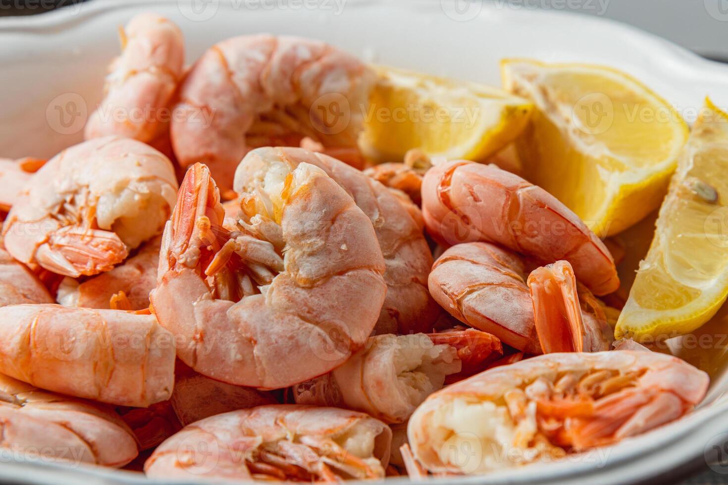 Boiled king prawns in a deep bowl with lemon photo