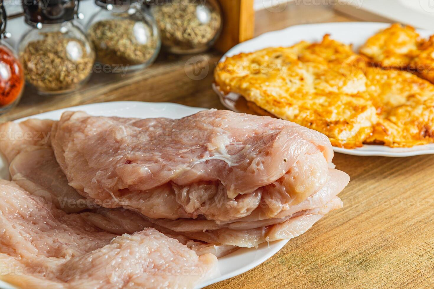 the process of cooking chicken chops with already fried chops in the background photo