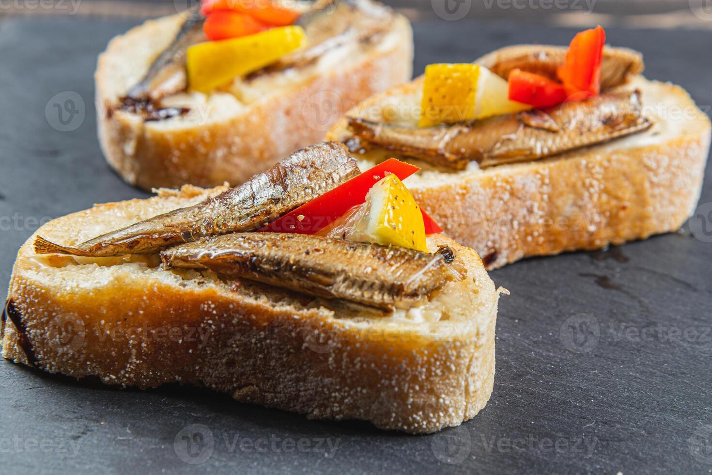 three fish sandwiches on a stone board on the table. selective focus photo