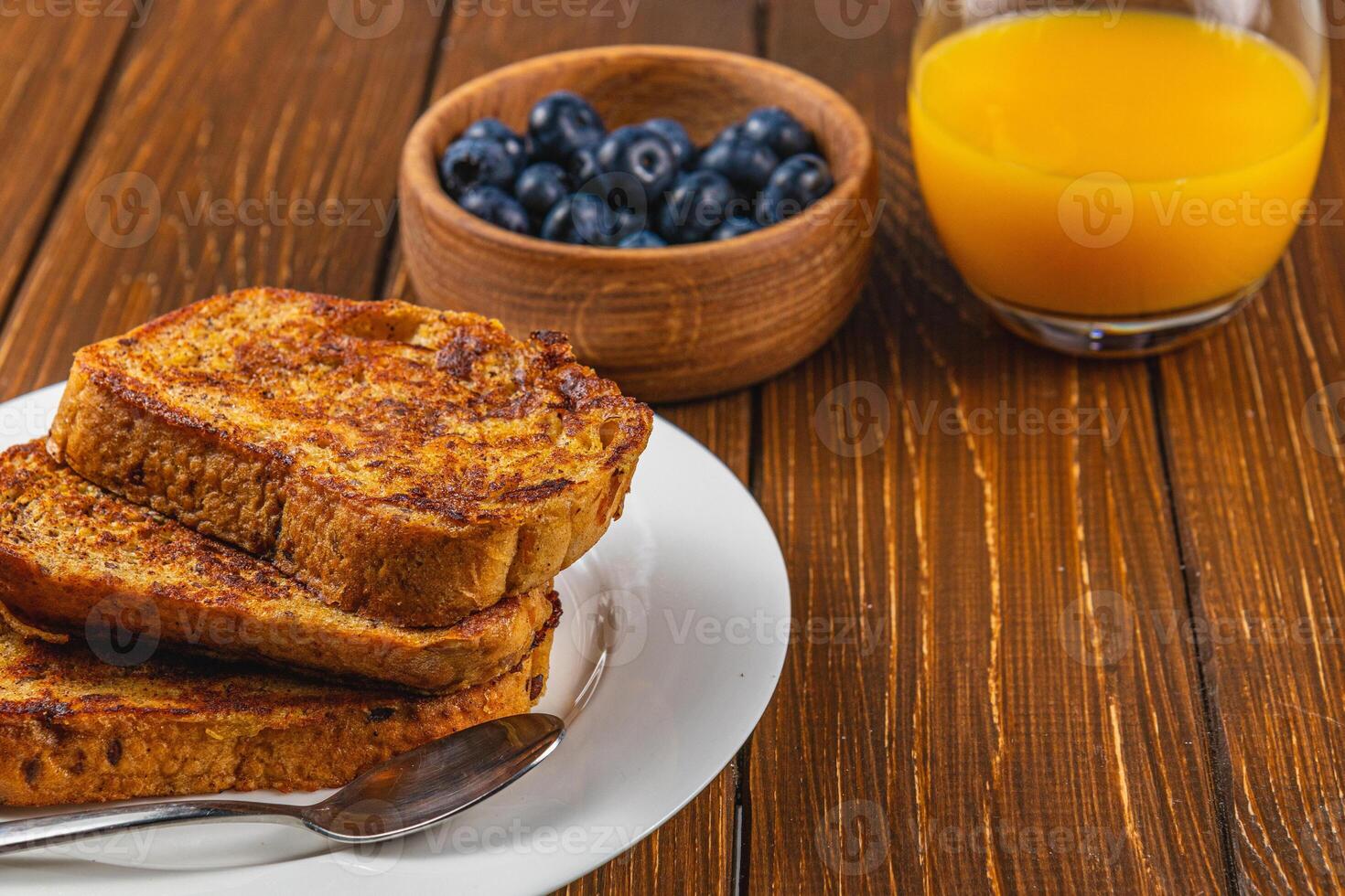 French toast on a white plate with blueberries and orange juice for breakfast photo