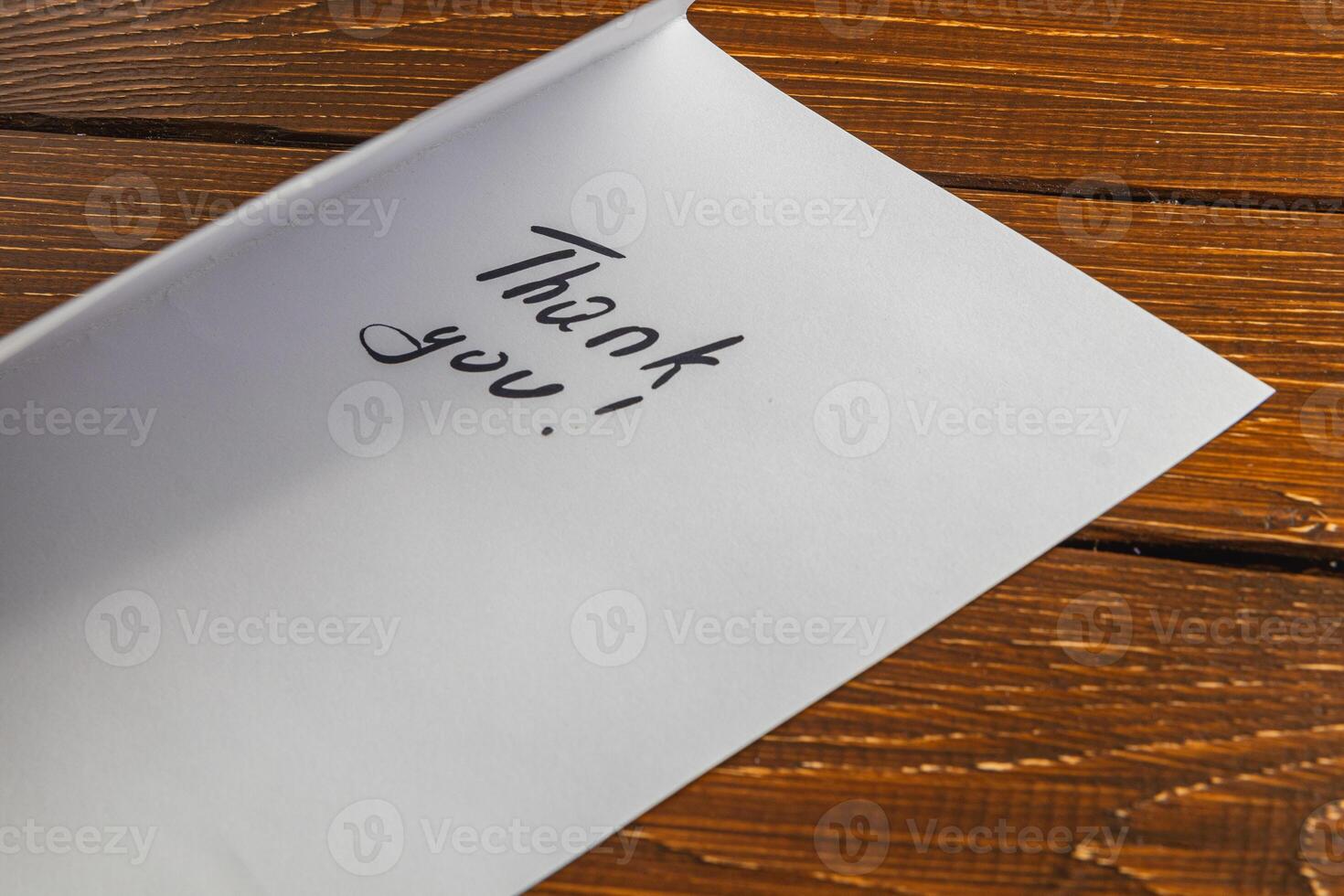 A person wrote words of thanks on a piece of paper on the table photo