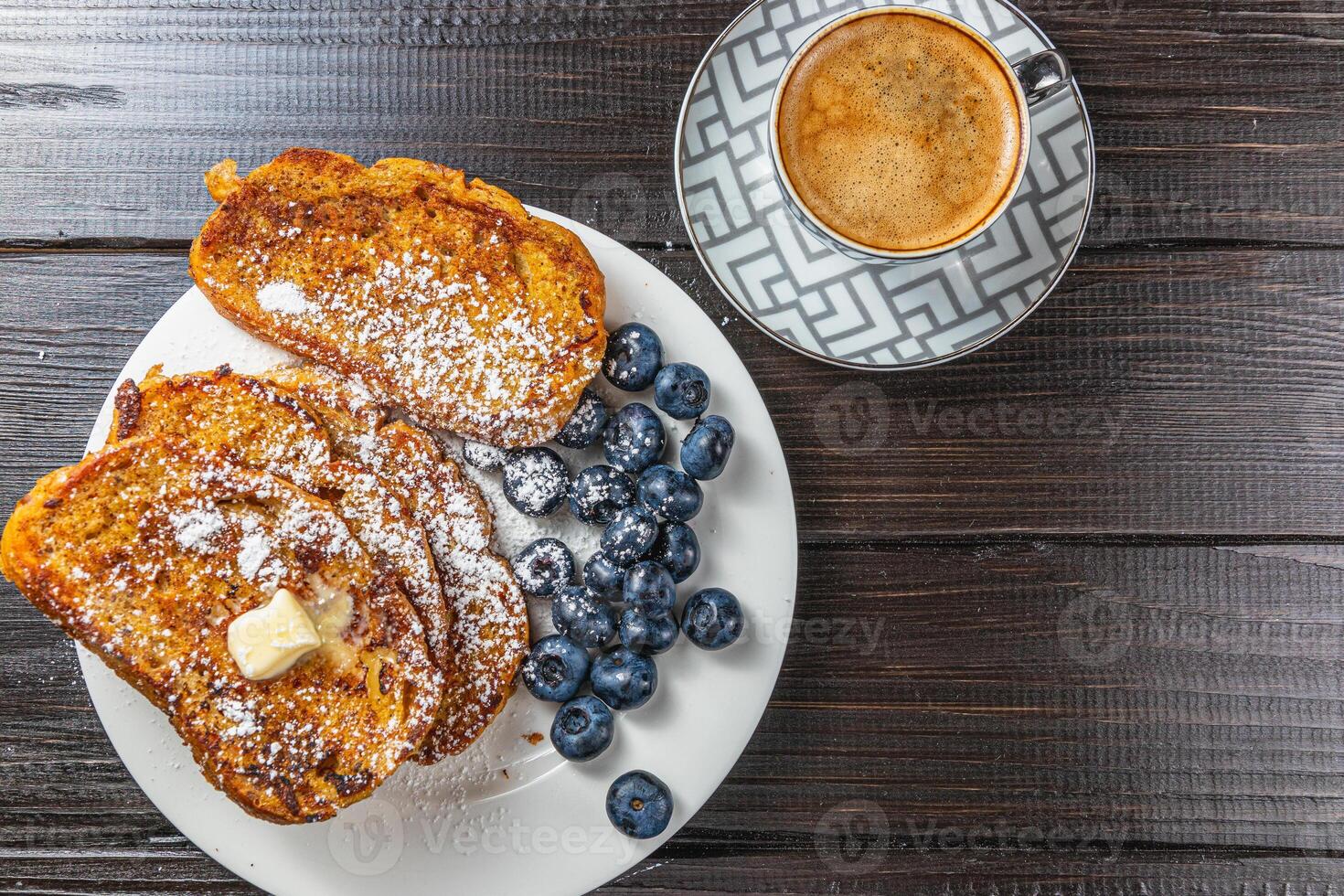 French toast on a white plate with blueberries and coffee for breakfast photo