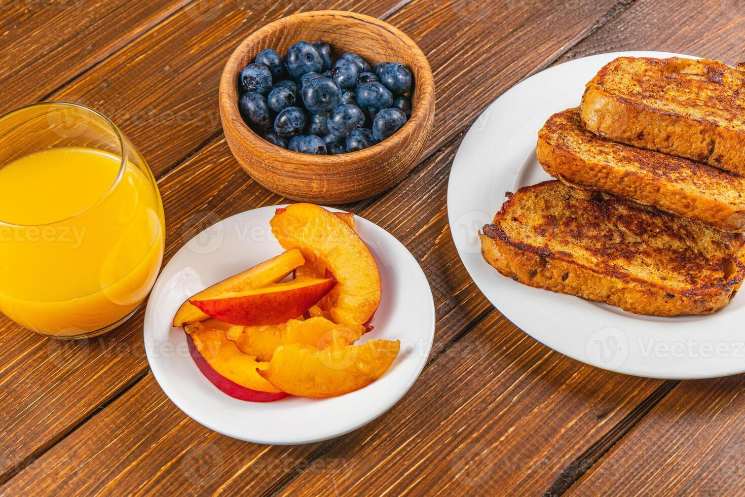 French toast on a plate with blueberries, orange juice, nectarine for breakfast photo
