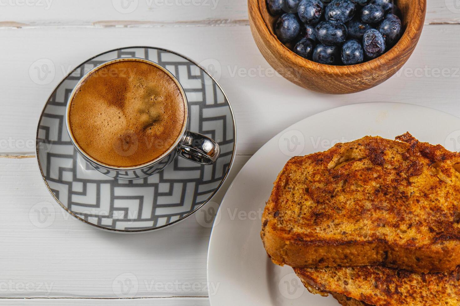 French toast on a white plate with blueberries and coffee for breakfast photo