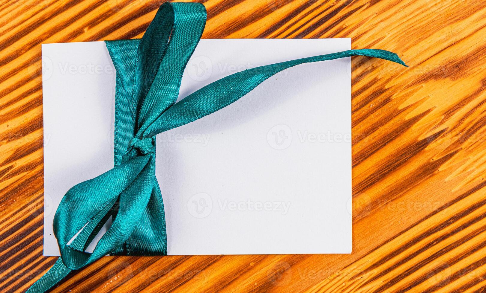 Blank note with green ribbon wooden , concept photo