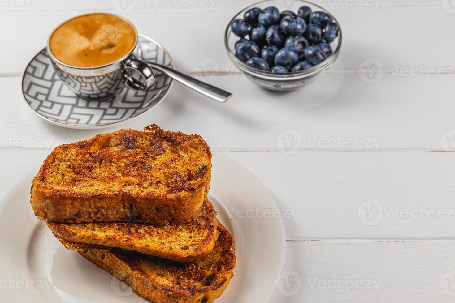 French toast on a white plate with blueberries and coffee for breakfast photo