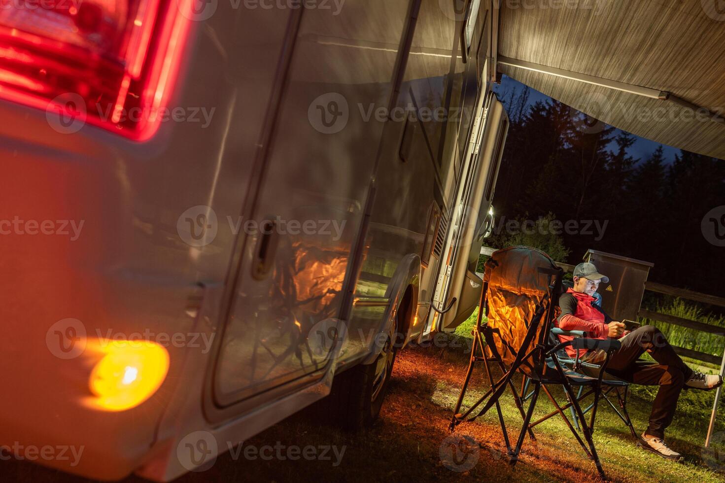 Relaxing at Dusk Next to a Cozy Camper in the Peaceful Wilderness photo