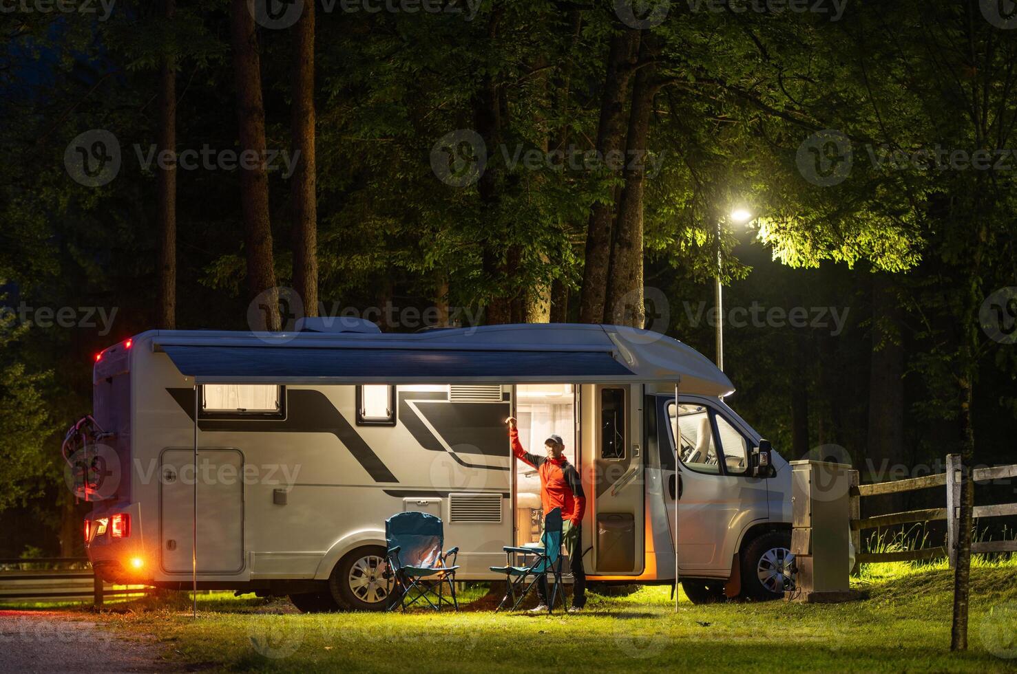 Relaxing Evening at a Campsite With a Camper Van Under the Stars Surrounded by Trees photo