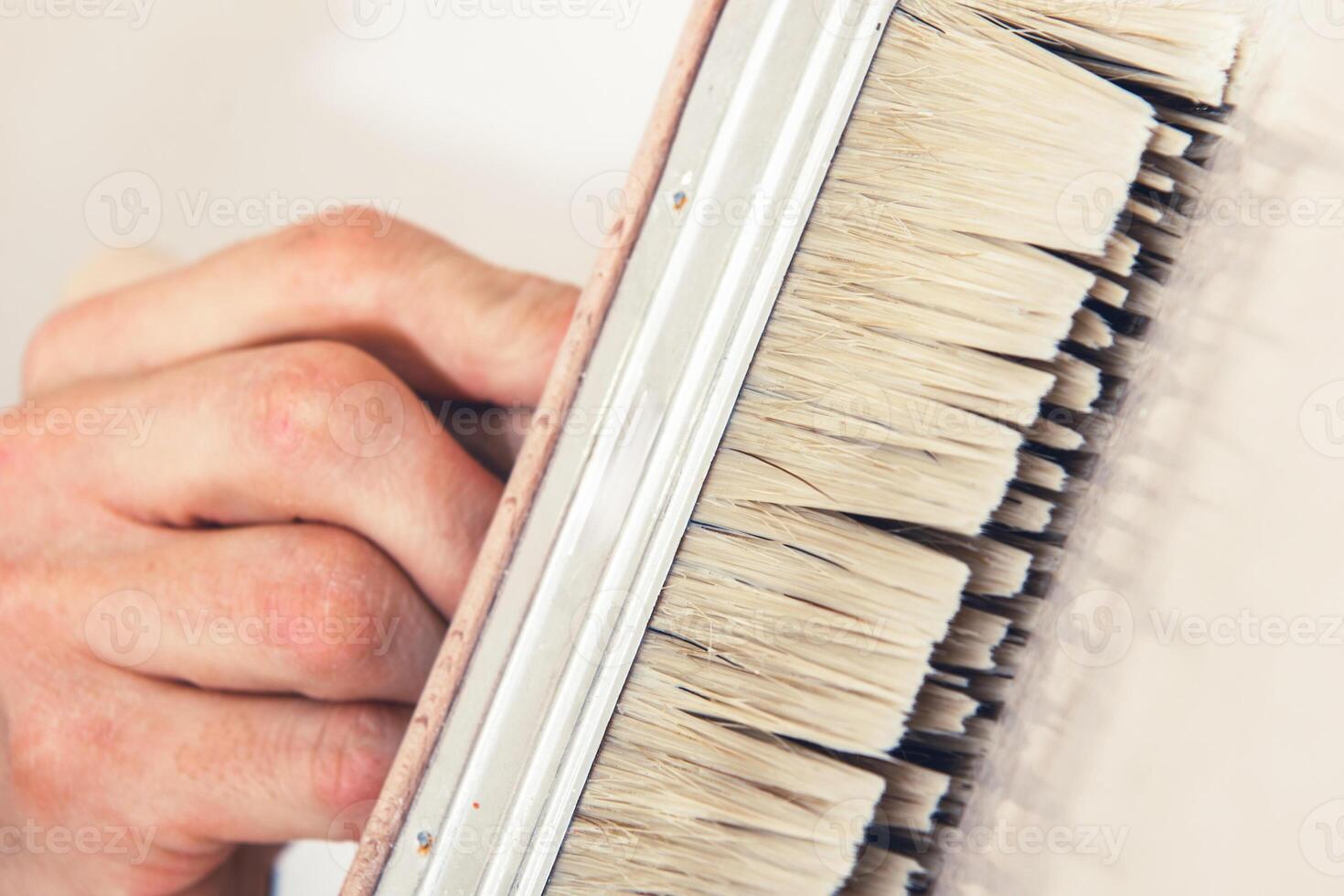 Person Carefully Painting a Surface With a Brush Using Precise Strokes in a Well-Lit Workspace photo