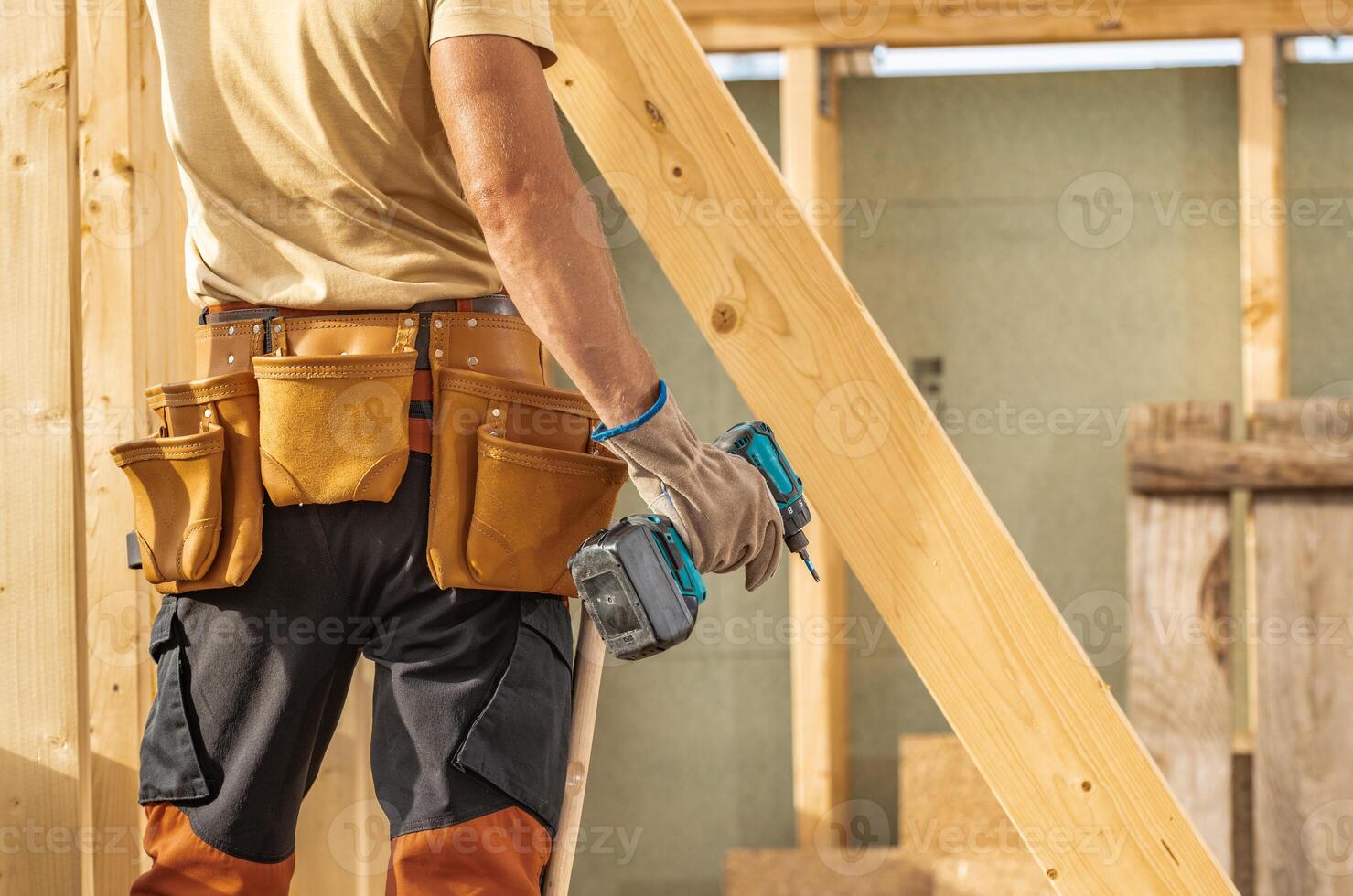 Construction Worker Using a Cordless Drill on a Building Site During Daylight Hours photo
